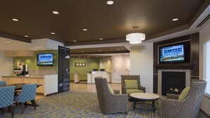 A hotel lobby with a fireplace, seating area, and a reception desk. - TownePlace Suites by Marriott Lexington South/Hamburg Place (Lexington)
