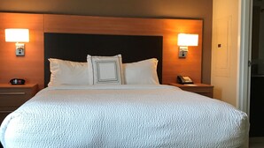 A hotel room with a large bed, two bedside tables, a headboard, and two wall-mounted lamps. - TownePlace Suites by Marriott Lexington South/Hamburg Place (Lexington)