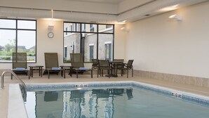 A swimming pool with a tiled edge, lounge chairs, and tables. - TownePlace Suites by Marriott Lexington South/Hamburg Place (Lexington)