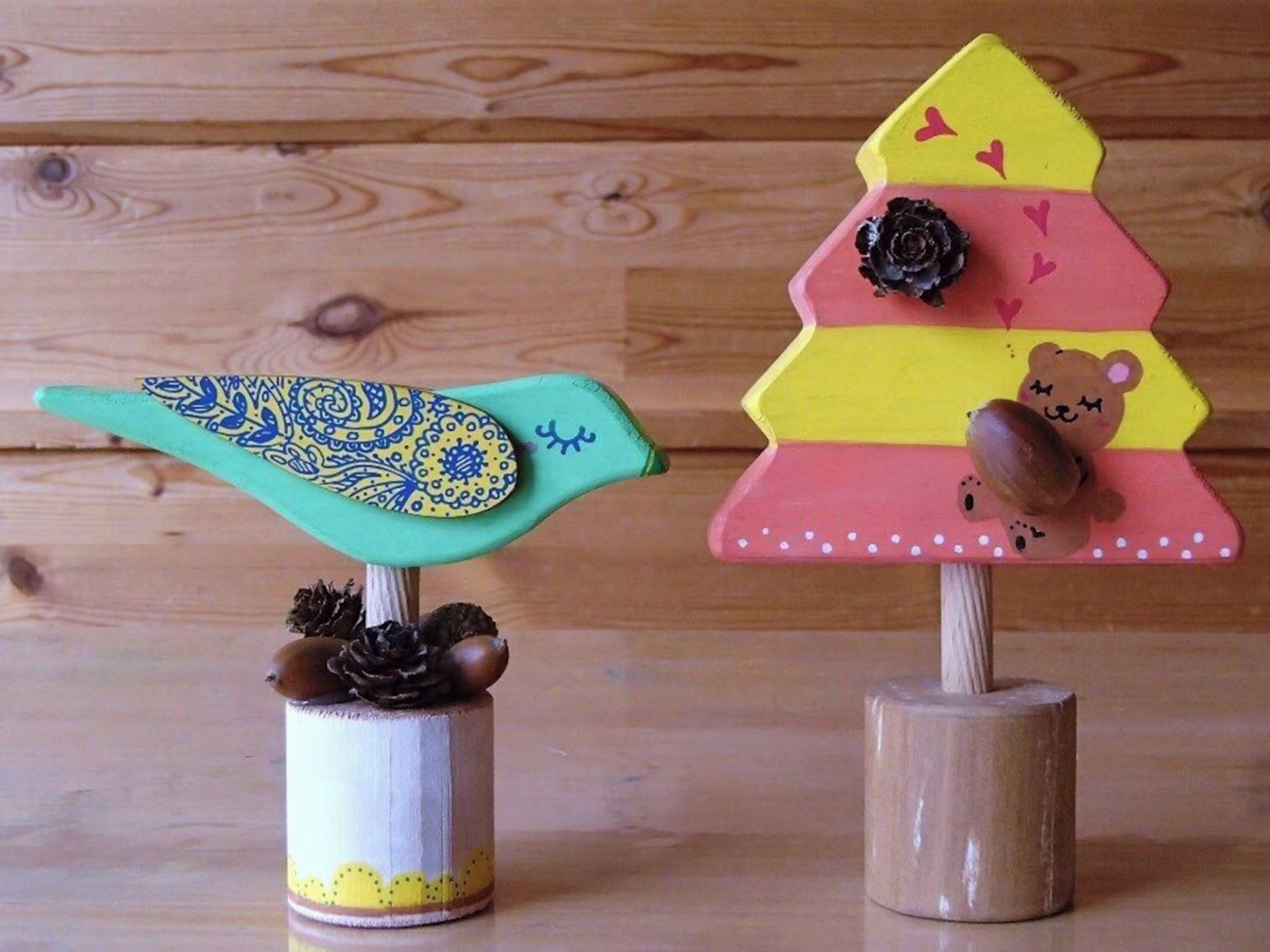 Duas árvores de Natal de madeira com enfeites decorativos.