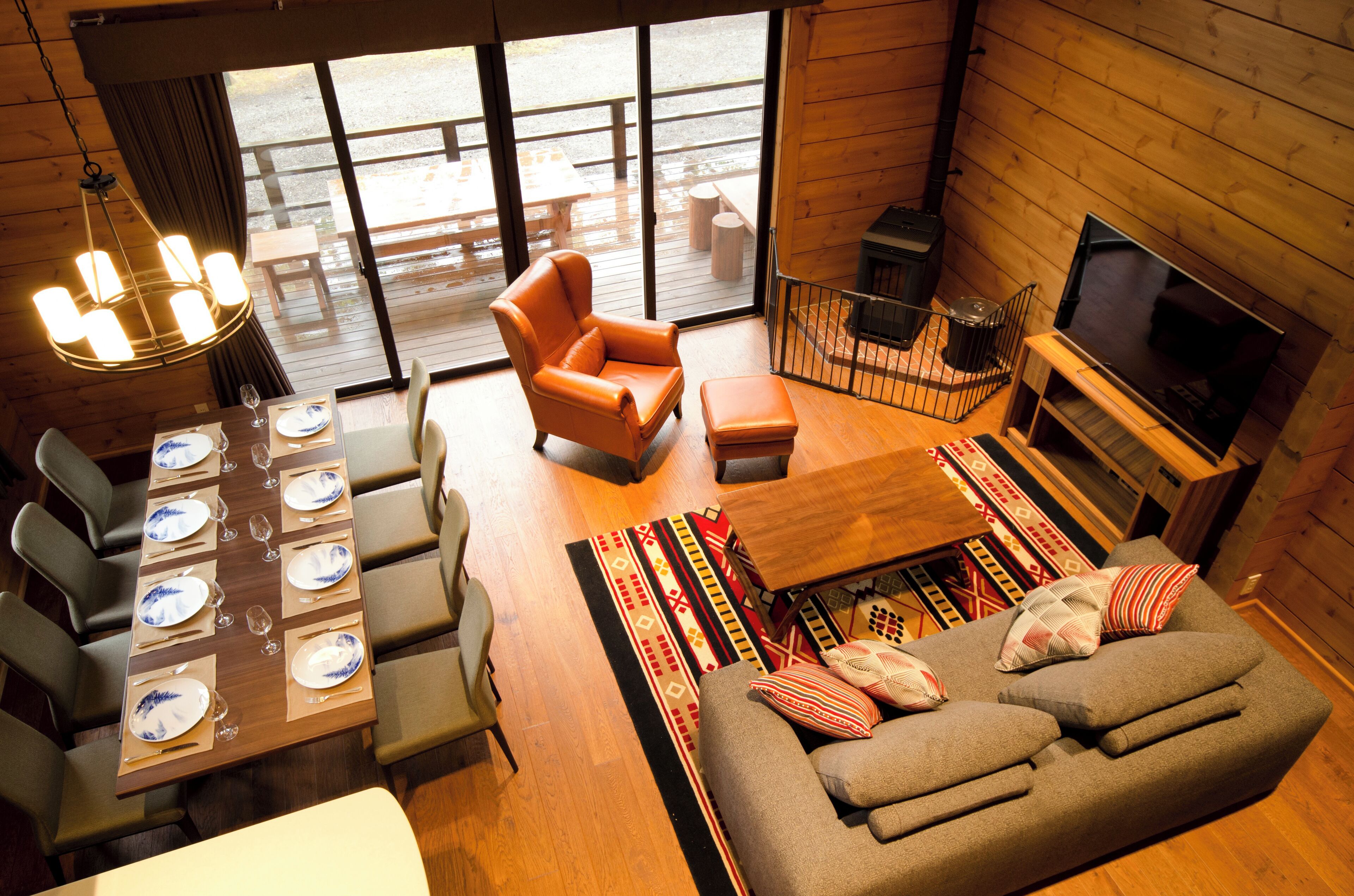 A cozy cabin interior with a dining area, sofa, and TV.