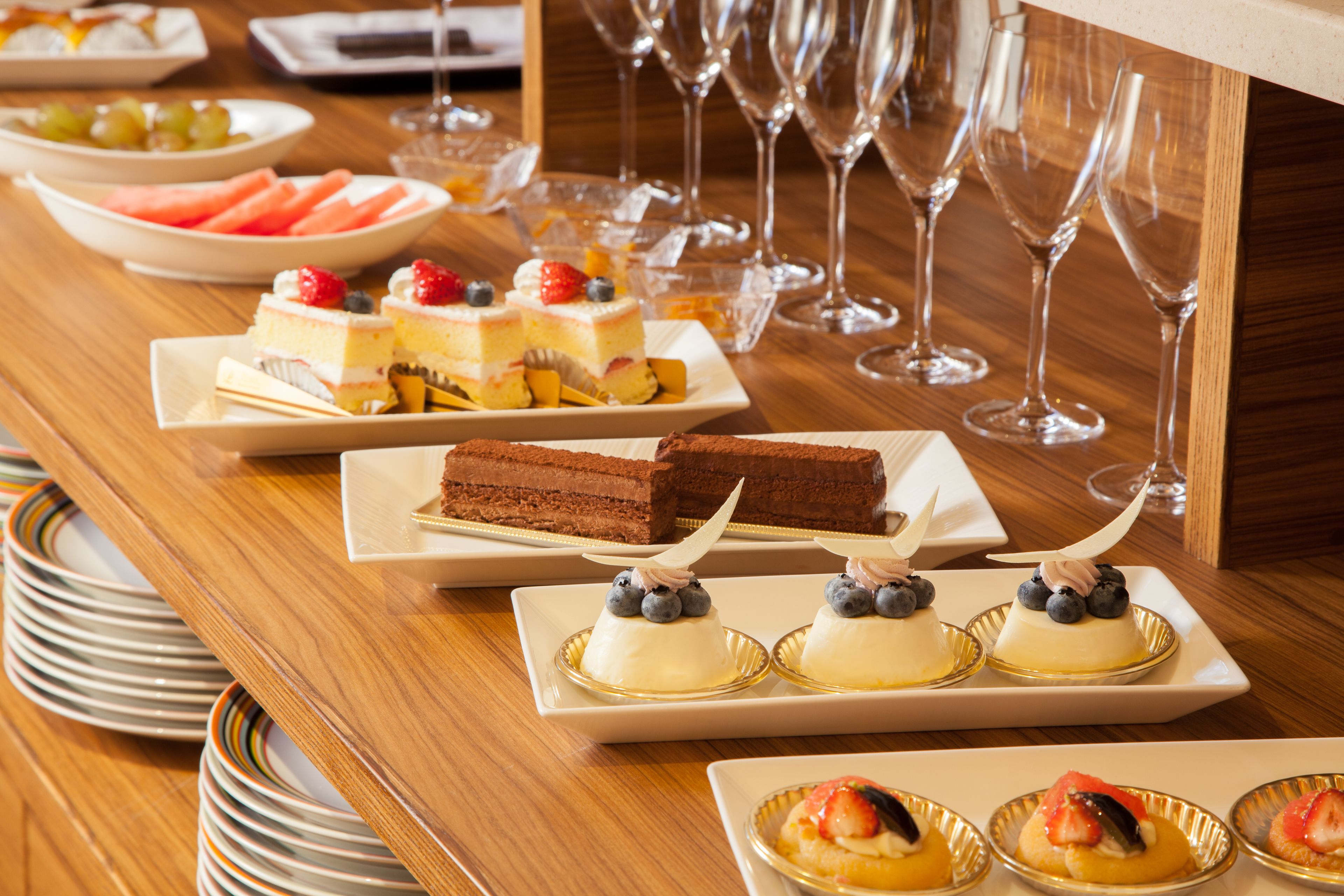 Een buffettafel met verschillende desserts en fruitplateaus.