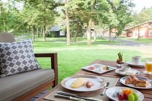 A dining table with plates of food, a cup, and a glass of orange juice.