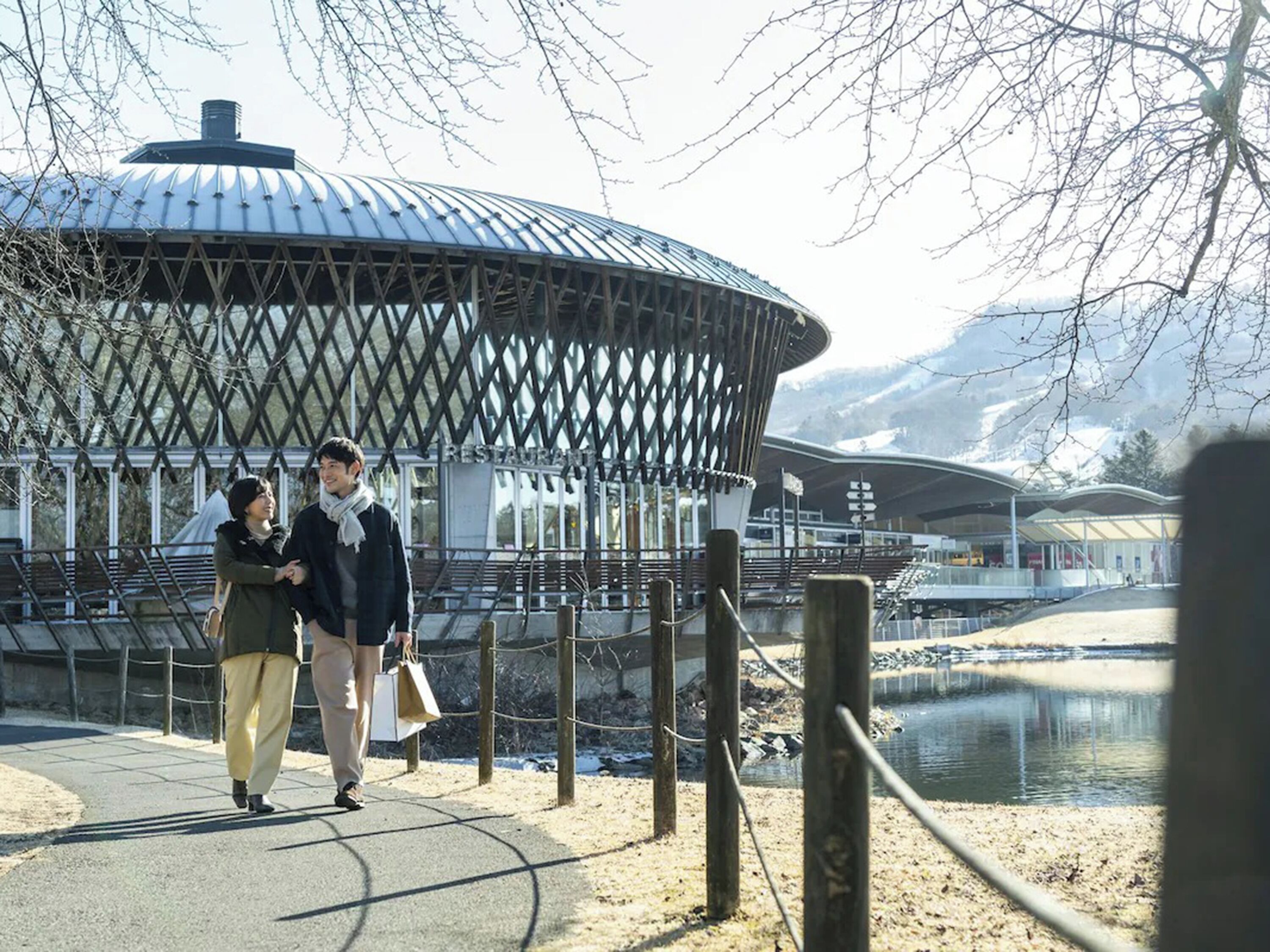 Une structure en forme de dôme, dotée d’une façade ajourée, d’un sentier et d’une étendue d’eau en arrière-plan.