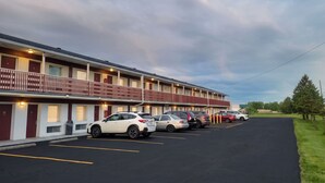 A motel with a row of parking spaces and a covered walkway. - Lake Erie Lodge Oregon OH (Curtice)