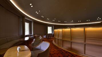 A hotel lobby with a curved ceiling, seating area, and a reception desk.