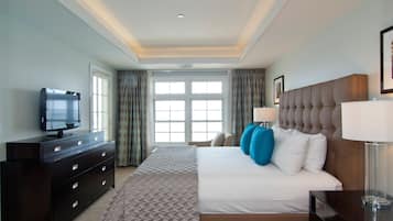 A hotel room with a large bed, a dresser with drawers, a television on the dresser, and a window with curtains.