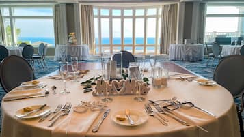 Taula de banquet ben aprofitada per a un esdeveniment formal, amb vista al mar.