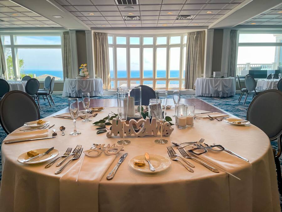 Taula de banquet ben aprofitada per a un esdeveniment formal, amb vista al mar.