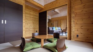 A room with tatami flooring, a round wooden table, and green cushions. - Karuizawa Asama Prince Hotel (Karuizawa)