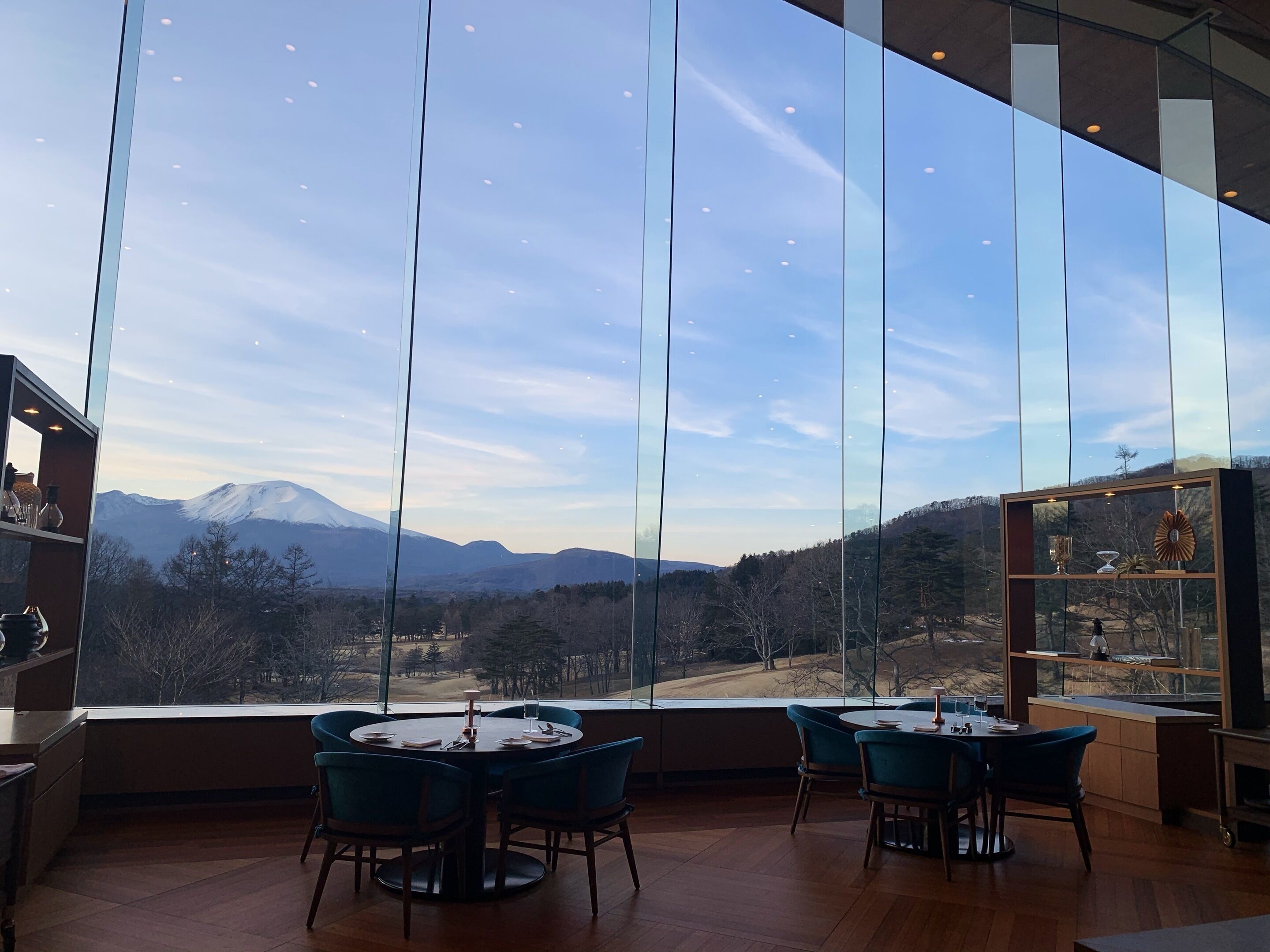 A dining area with a large window offering a mountain view.