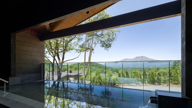 A modern indoor pool with a clear view of the surrounding landscape and a mountain in the distance. - Karuizawa Asama Prince Hotel (Karuizawa)