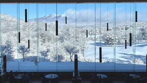 A modern interior with large windows offering a snowy mountain view. - Karuizawa Asama Prince Hotel (Karuizawa)