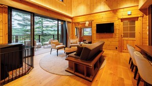 A spacious wooden cabin interior with a large sofa, chairs, a TV, and a fireplace. - Karuizawa Asama Prince Hotel (Karuizawa)