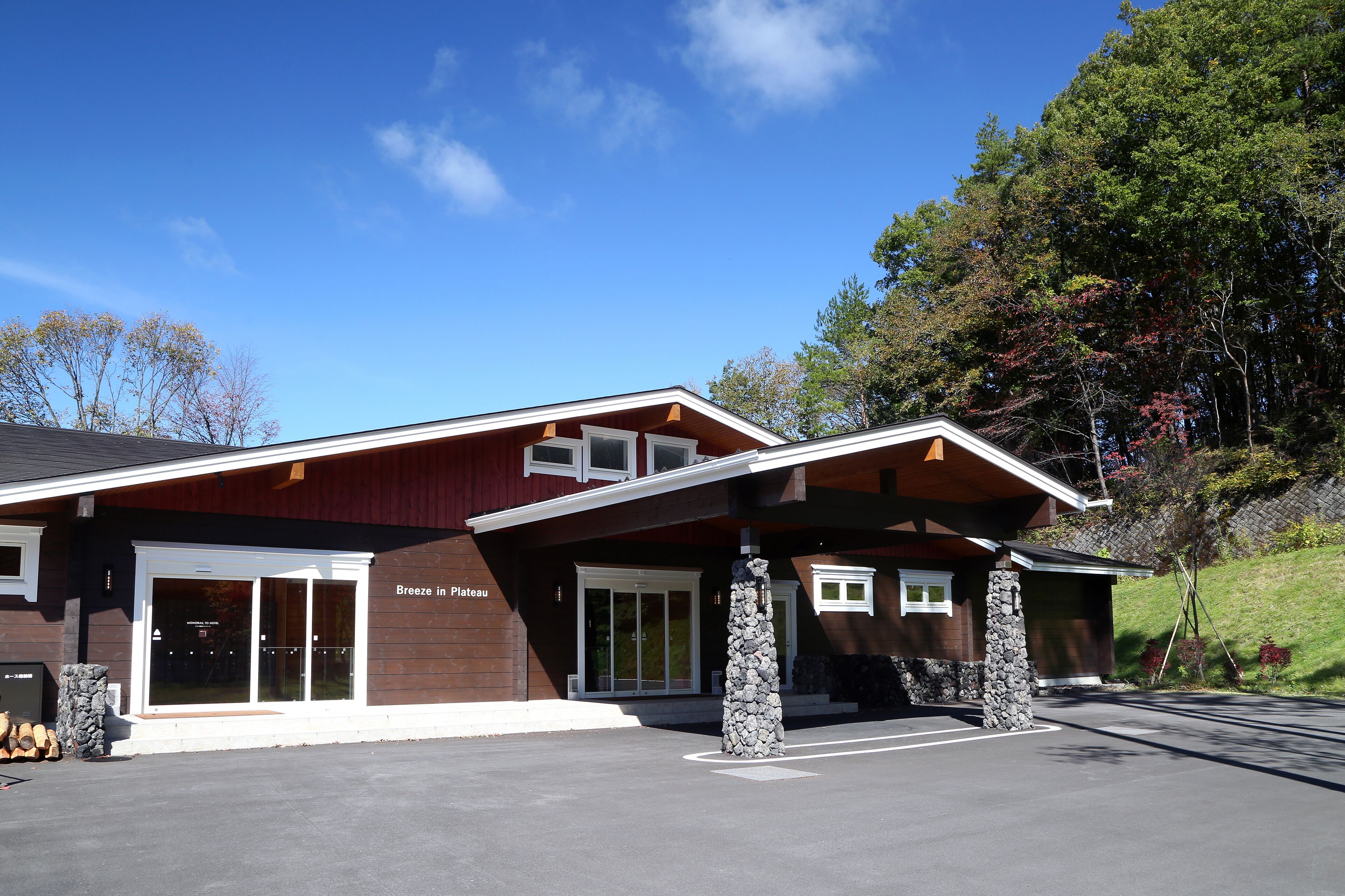 A modern building with a stone pillar, a covered entrance, and a sign that reads "Breeze in Plateau."