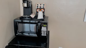A coffee machine with a digital display, a coffee pot, a cup, and a coffee pod. - Ashland Motel - Oregon (Ashland)