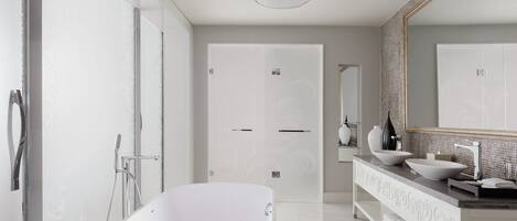 A modern bathroom with a freestanding bathtub, a large mirror, and a walk-in shower.