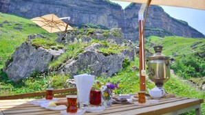 A table set outdoors with a view of a mountainous landscape. - Pik Palace, Shahdag, Autograph Collection (Qusar)