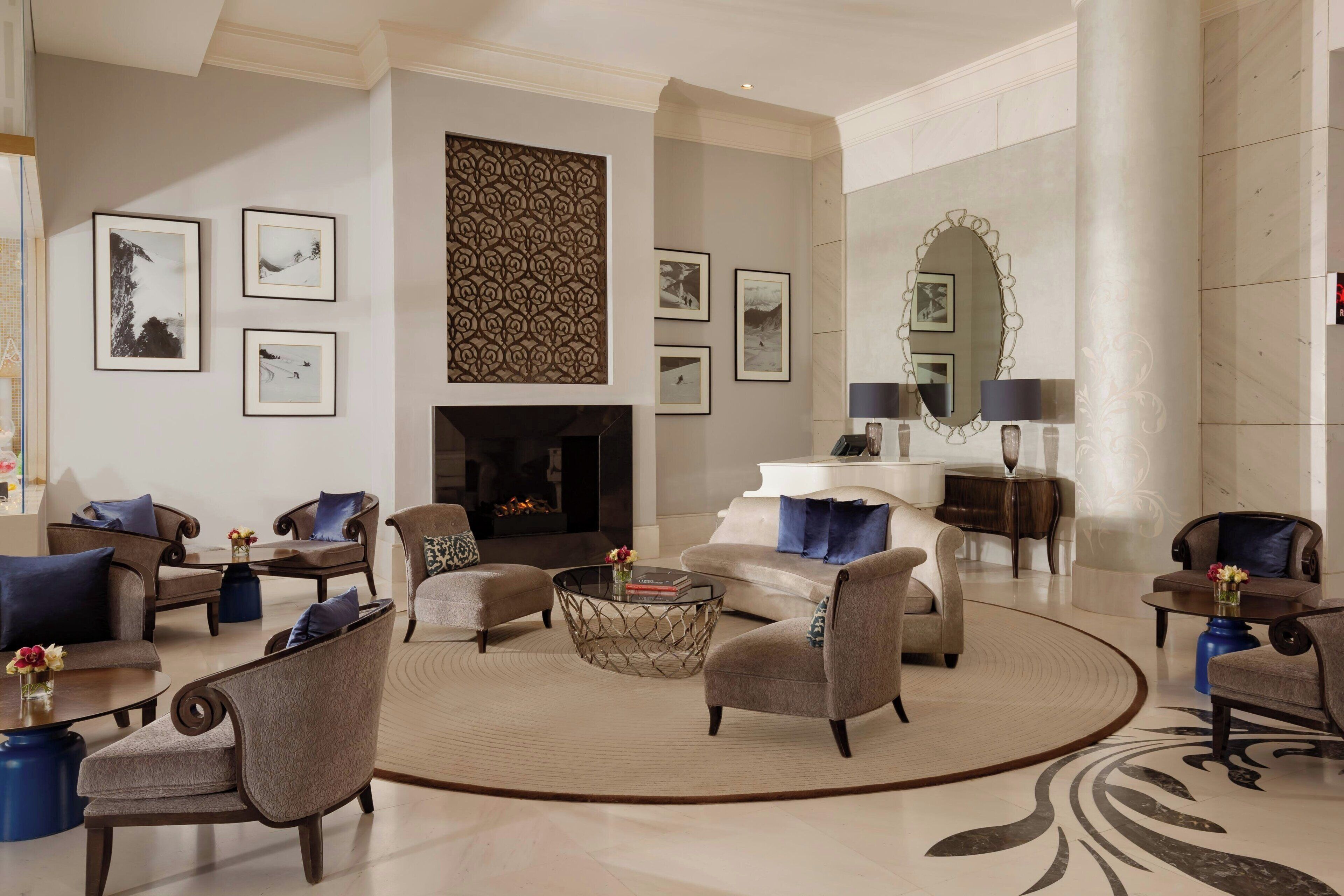 A spacious living room with a fireplace, comfortable seating, and a large mirror.