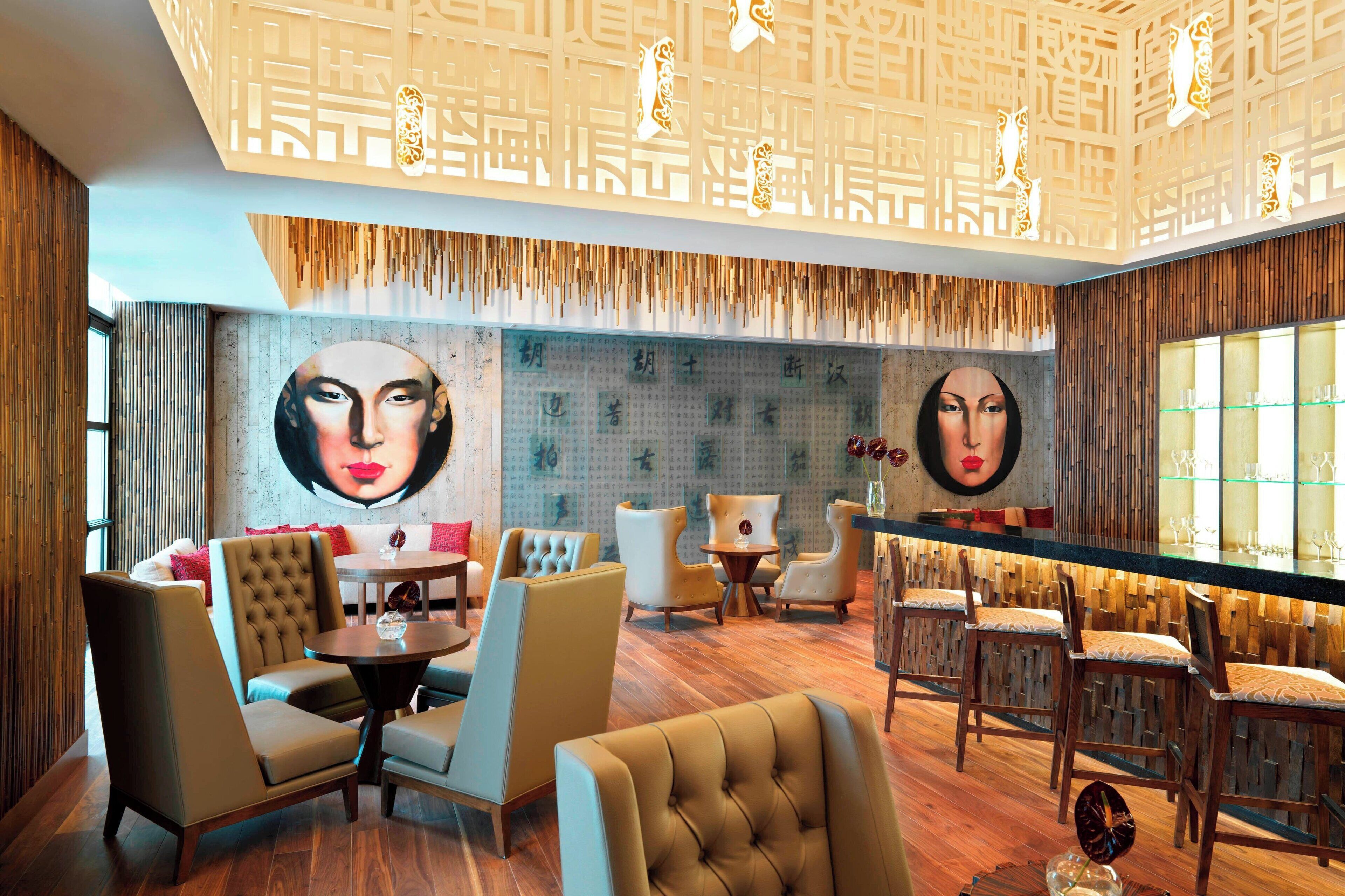 A modern interior with a bar area, seating arrangements, and decorative wall art.