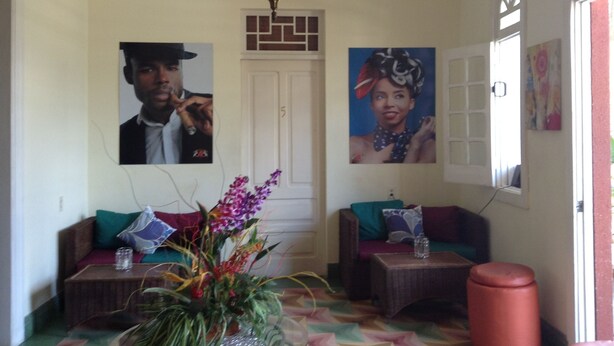 A living room with two sofas, a chandelier, and two framed pictures on the wall. - Adam Suites (Santo Domingo)