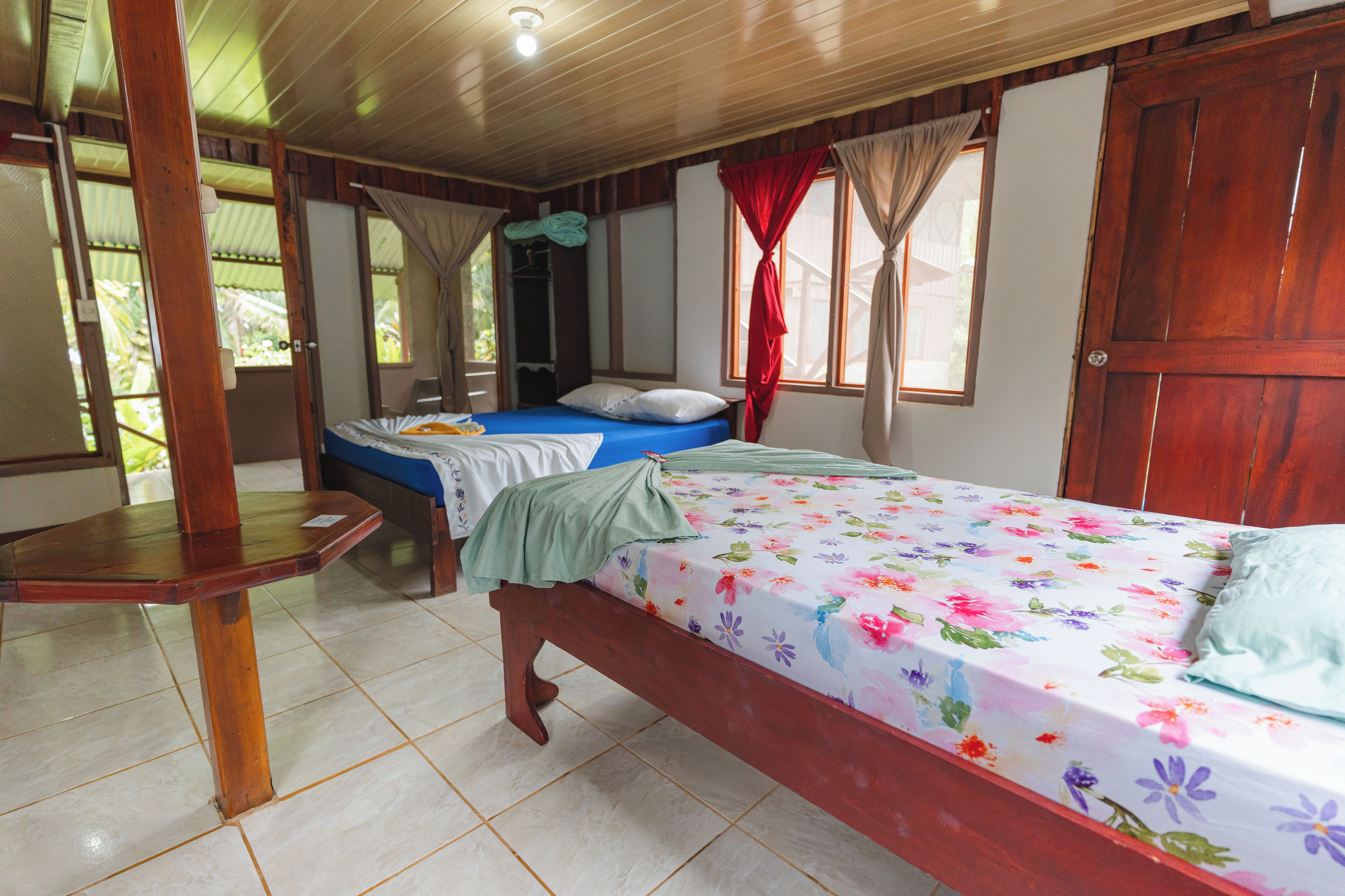 A room with a bed, a wooden table, and a wardrobe.