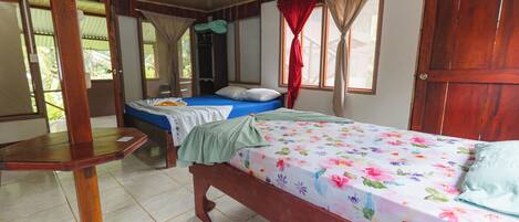 Una habitación con una cama, una mesa de madera y un armario.