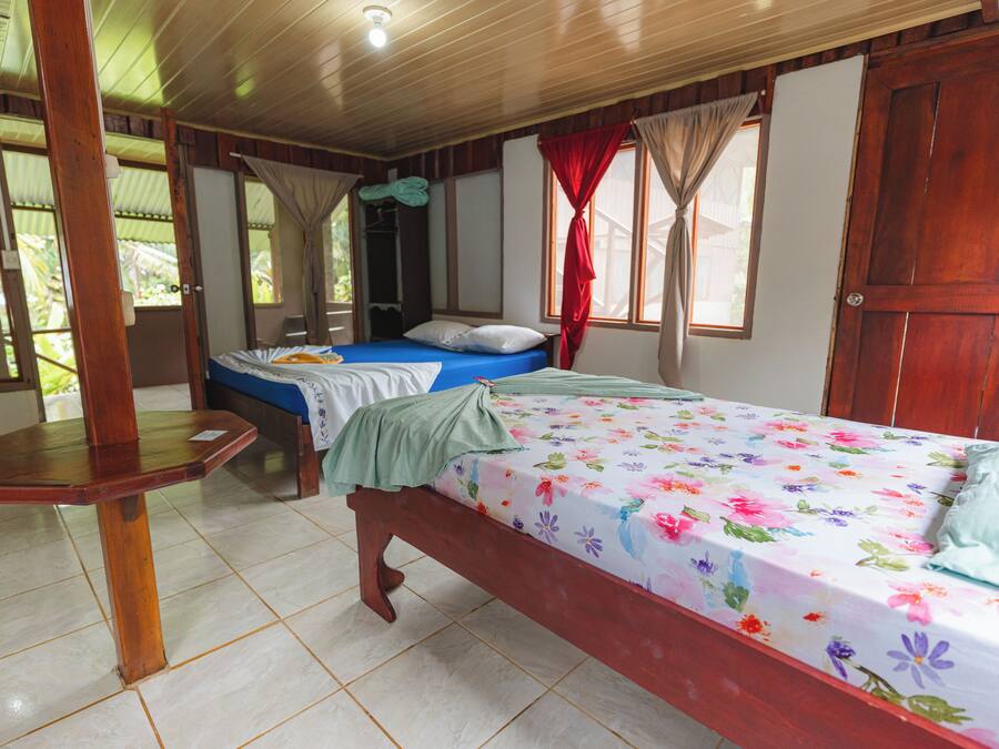A room with a bed, a wooden table, and a wardrobe.
