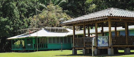 Un edificio verde con un porche cubierto y un cartel que indica que es un parque.