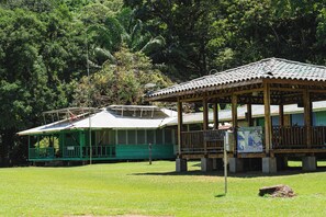 A green building with a covered porch and a sign indicating it is a park. - Poor Man's Paradise (Drake Bay)