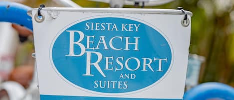 Un cartel en una bicicleta con el texto 'Siesta Key Beach Resort and Suites' y un número de teléfono.