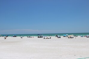 Nær stranden, hvit sand og strandhåndklær
