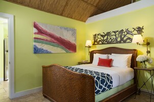 Un dormitorio con cama, un cuadro en la pared, un adorno decorativo y una mesita de noche con lámpara.