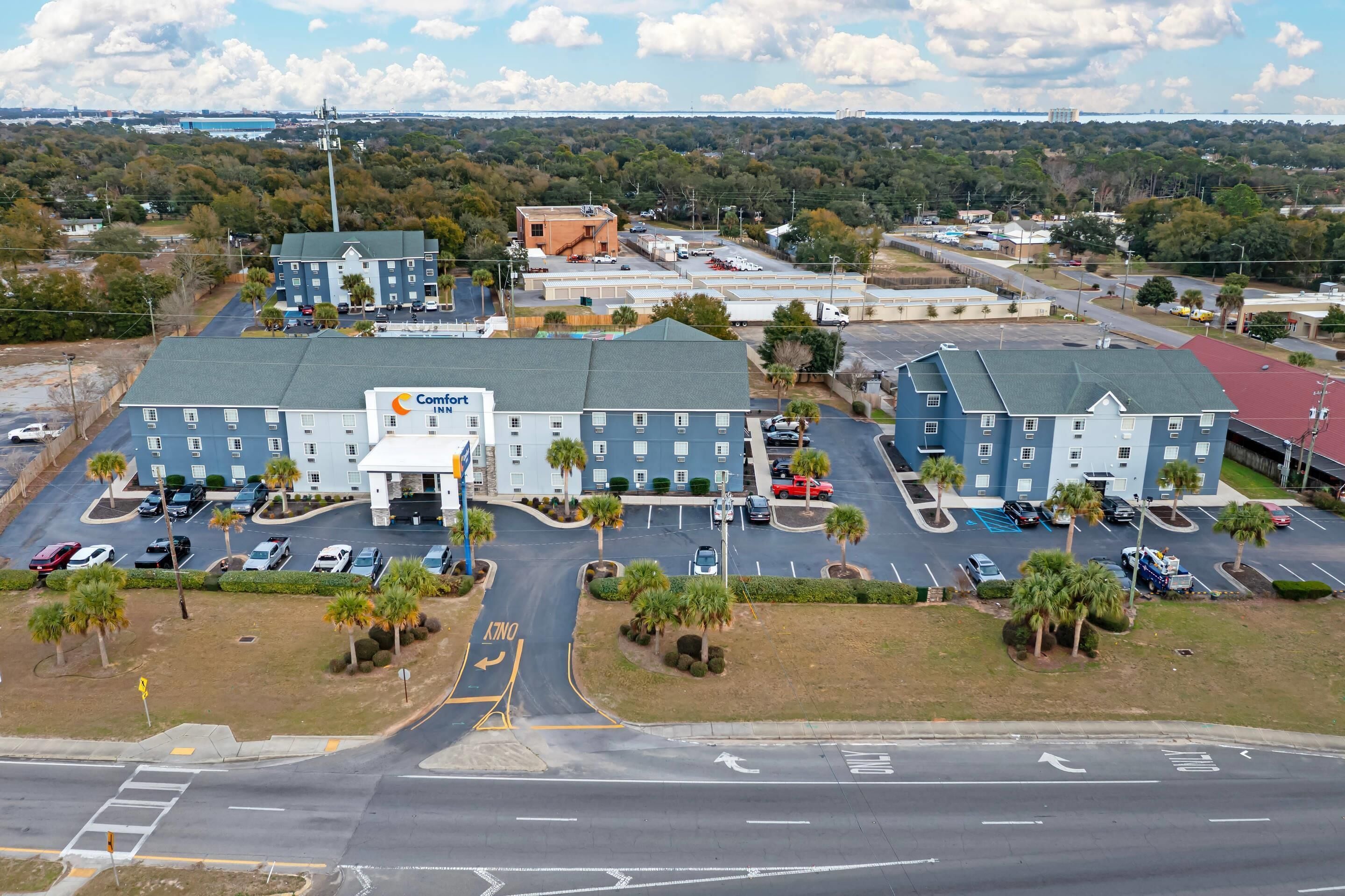 A hotel with multiple buildings, parking lots, and a road in the foreground.