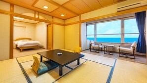 Una habitación con cama, una mesa y vista al mar.
