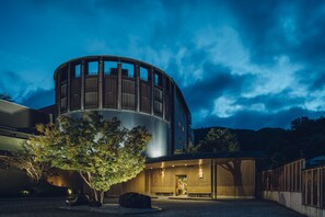 Un bâtiment moderne à la structure cylindrique, doté d’un espace d’entrée abrité.
