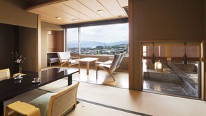 A modern hotel room with tatami seating, a large window offering a city view, and a traditional Japanese aesthetic. - Hoshino Resorts KAI Matsumoto (Matsumoto)