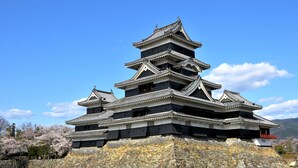 A traditional Japanese castle with multiple tiers, stone base, and a surrounding moat. - Hoshino Resorts KAI Matsumoto (Matsumoto)
