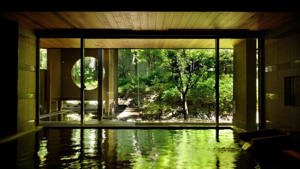 A serene indoor pool with a view of a lush garden through large windows. - Hoshino Resorts KAI Matsumoto (Matsumoto)