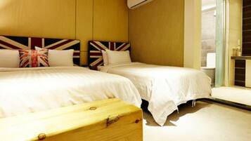 A hotel room with two beds, a wooden headboard, and a large window.