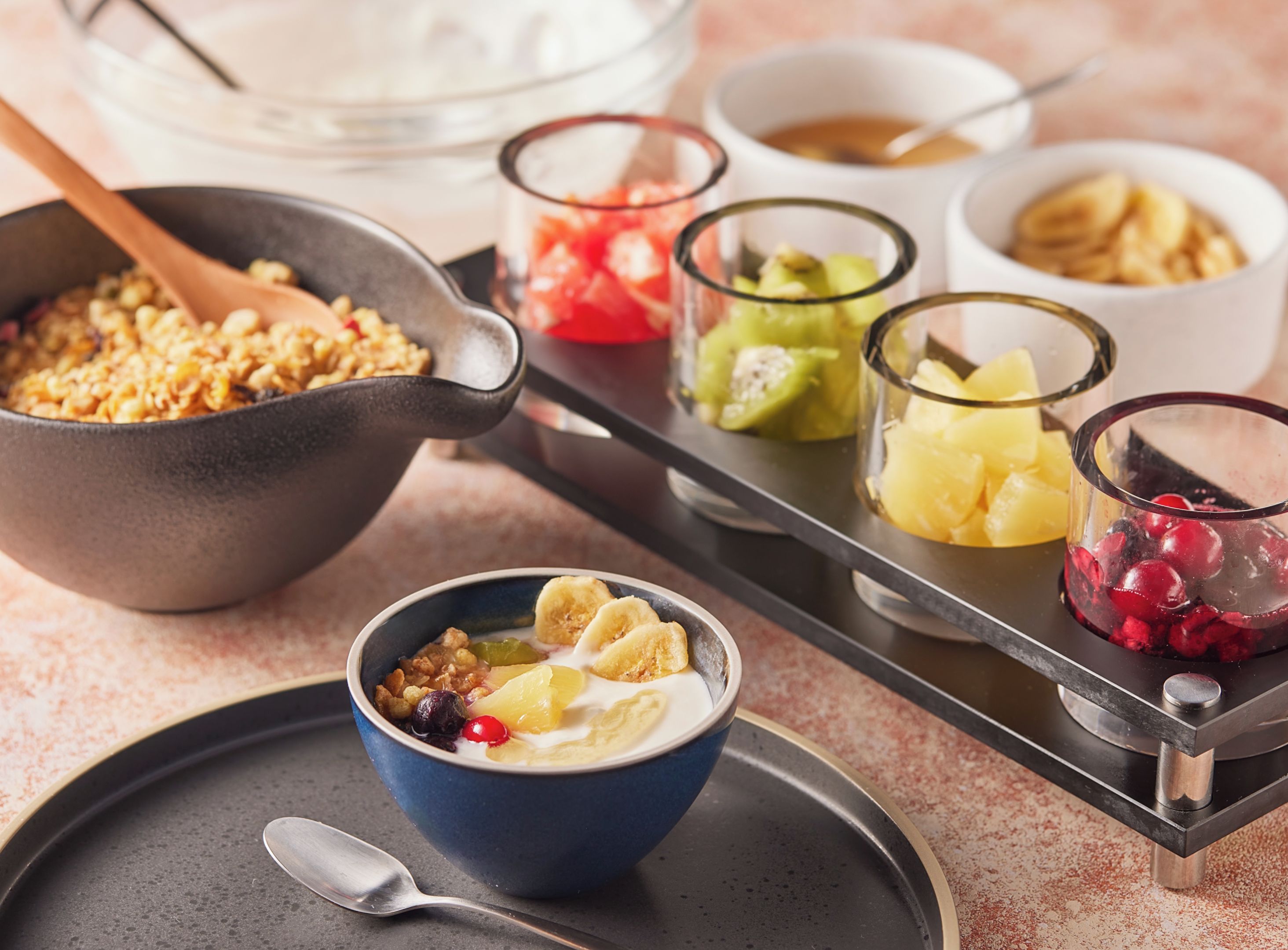 Safata de petitdejuni amb diferents aliments, com ara cereals, iogurt i fruita.