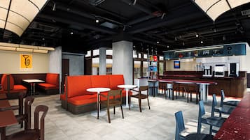 A modern restaurant interior with seating arrangements, a bar area, and a visible menu board.