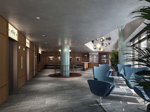 Una hall moderna con una colonna centrale, un'area salotto e una reception.