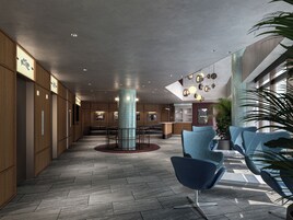 A modern lobby with a central column, seating area, and a reception desk.