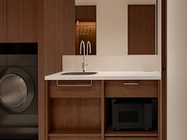 A modern bathroom with a built-in washing machine, a sink with a mirror, and wooden cabinetry.