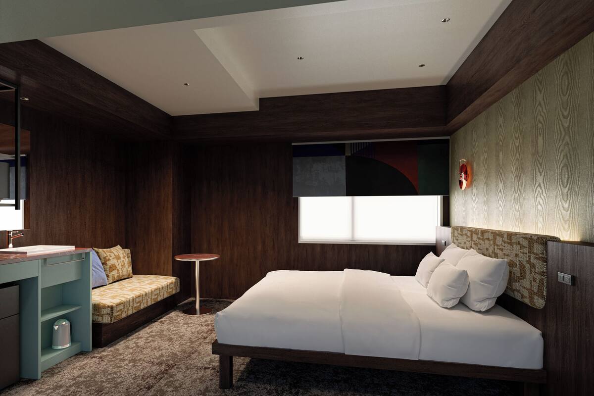 Una camera da letto moderna con un letto, un comodino e un piccolo tavolino rotondo.
