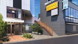 Un bâtiment moderne, sur lequel on peut lire l’inscription « TOKYU STAY », et un escalier menant à l’entrée.