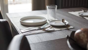 A neatly set dining table with plates, cutlery, and a glass.
