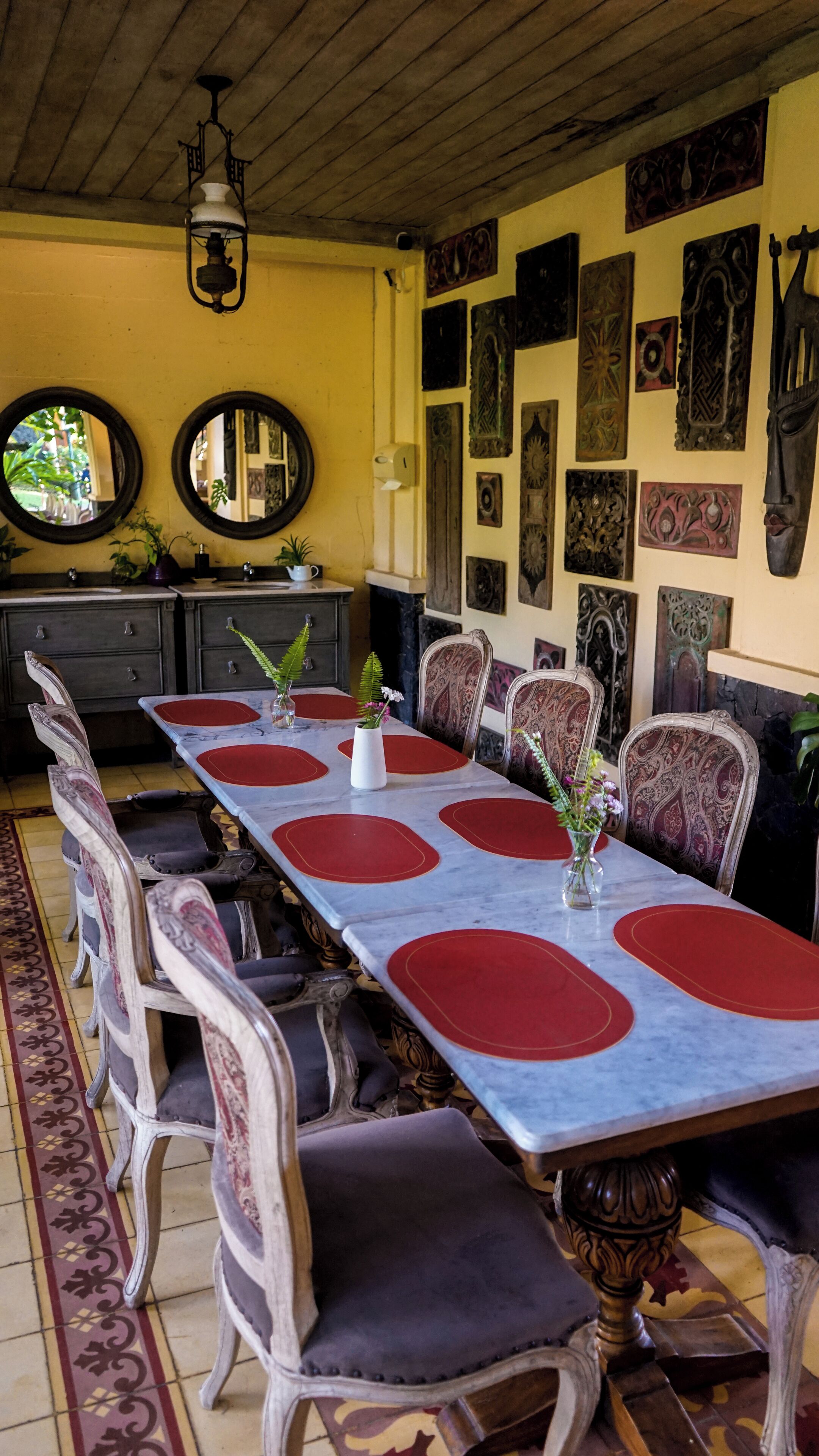 Un comedor con una larga mesa, sillas ornamentadas y decoración en las paredes.