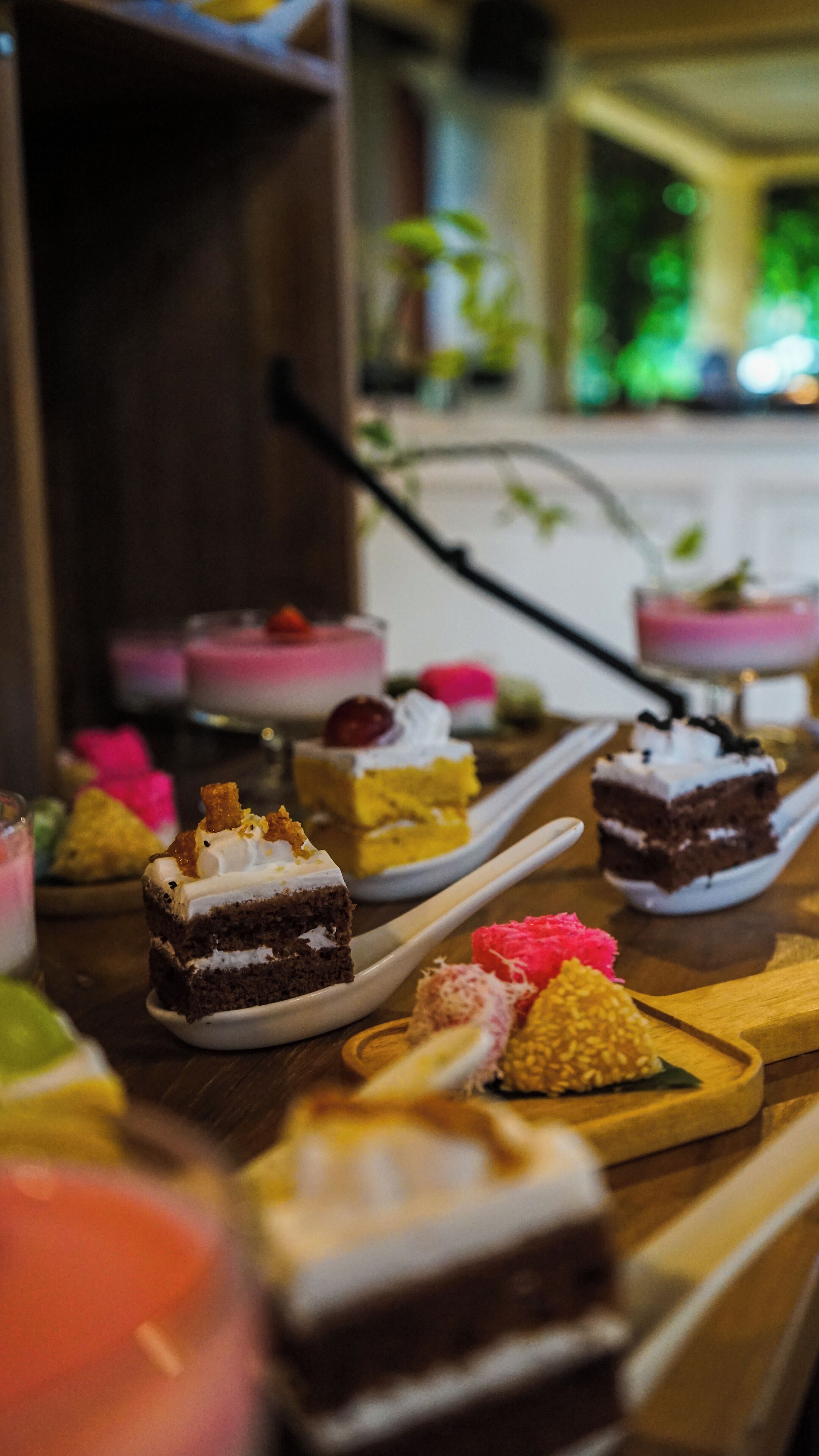 A variety of desserts on a wooden table, including cakes and pastries.